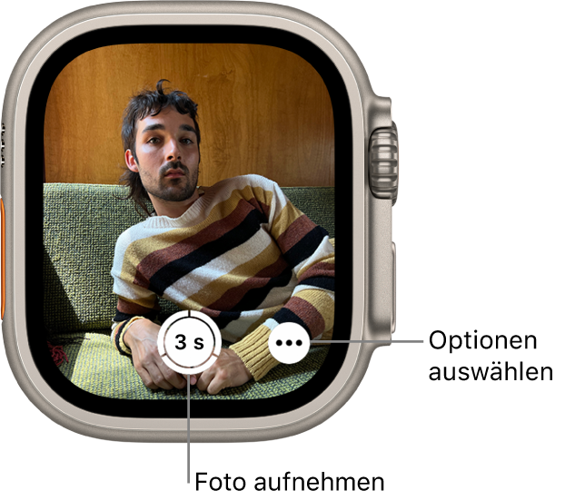 Die Apple Watch wird als Kamerafernbedienung verwendet. Auf dem Display ist das Kamerabild des iPhone zu sehen. Die Taste „Bild aufnehmen“ befindet sich unten in der Mitte und die Taste „Weitere Optionen“ rechts davon. Wenn du ein Foto aufgenommen hast, befindet sich unten links die Taste zum Anzeigen des Fotos.