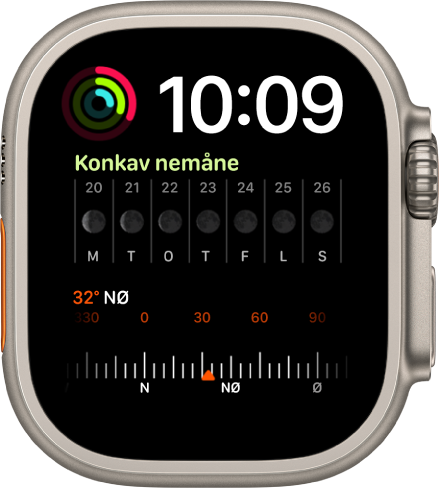 Modulær duo-urskiven som viser en digital klokke øverst til høyre, en Aktivitet-komplikasjon øverst til venstre, en Månefase-komplikasjon i midten og en Kompass-komplikasjon nederst.