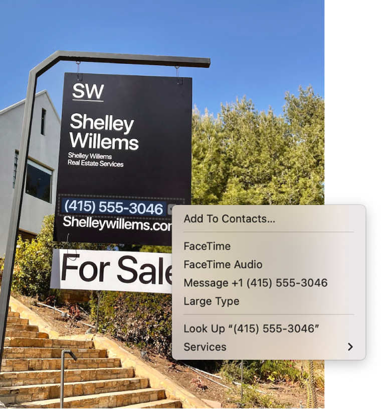 A photo of a real estate For Sale sign showing the agent’s phone number selected as Live Text and a menu presenting options to add the phone number to Contacts, call the number, start a FaceTime call, send a text message, and more.