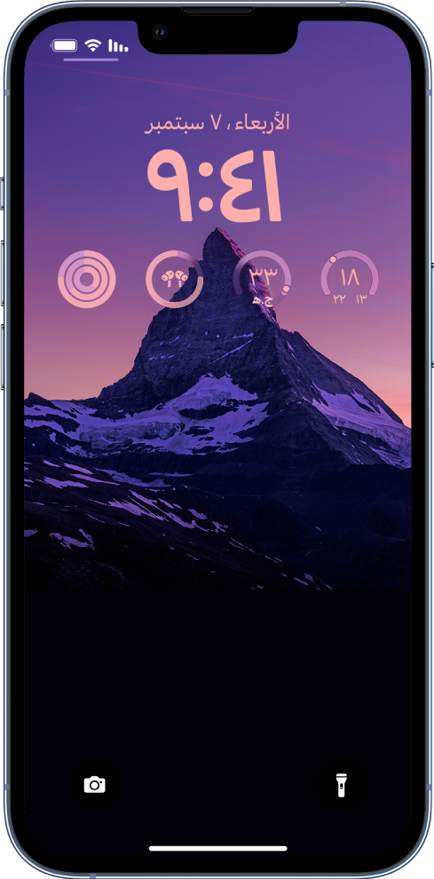 شاشة قفل مخصصة على iPhone، بها صورة في الخلفية وأدوات أعلى الشاشة لدرجة الحرارة ومؤشر جودة الهواء ومستوى بطارية AirPods وحلقات اللياقة البدنية.