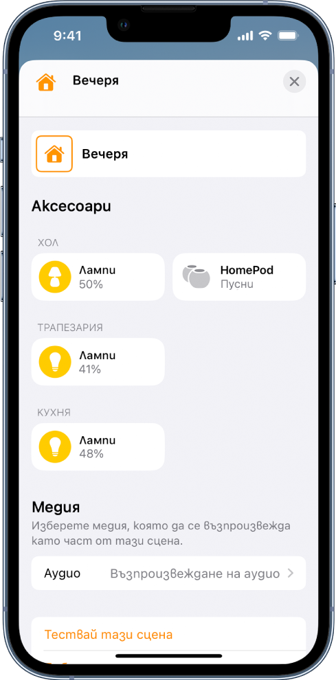 Екран за редактиране на сцена в приложението Дом. Името на сцената е в горната част на екрана. Под него има три стаи и аксесоарите, които са добавени към всяка стая като част от сцената. Близо до долната част на екрана има секция Медия, където е настроен HomePod да възпроизвежда аудио във всекидневната. В дъното на екрана има бутон Тестване на сцената.