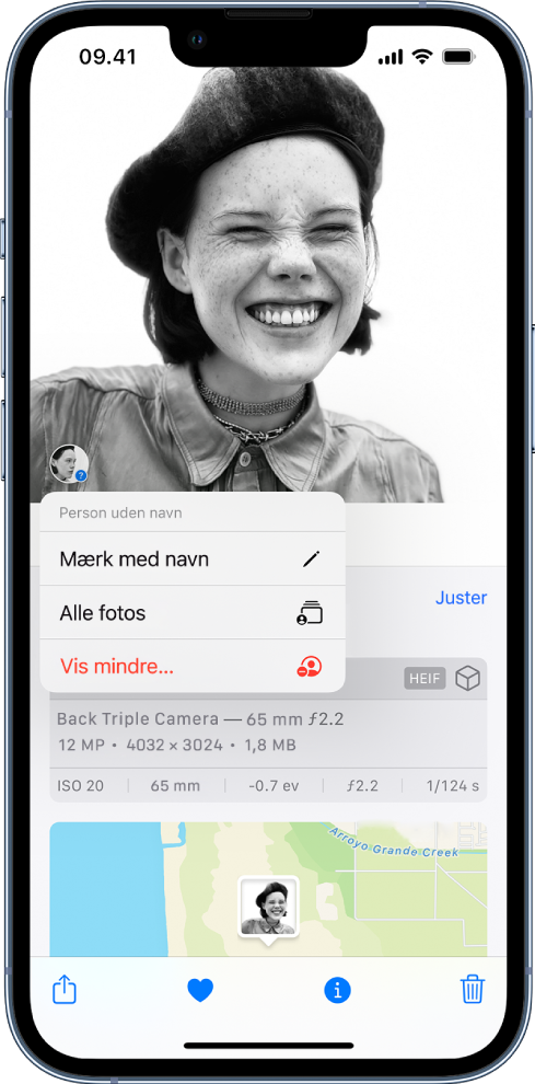 Et foto er åbent i den øverste halvdel af skærmen. Den person, der er identificeret på fotoet, vises på et mærke i fotoets nederste venstre hjørne. Under mærket findes følgende muligheder: Mærk med navn, Alle fotos og Vis mindre.
