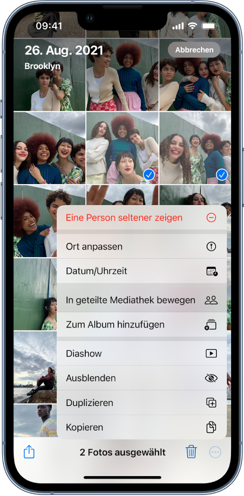 Ein Raster mit Fotominiaturen füllt den Bildschirm. Zwei der Miniaturen sind ausgewählt und das Menü „Mehr“ unten auf dem Bildschirm ist geöffnet. Die Option „In geteilte Mediathek bewegen“ ist im Menü ausgewählt.