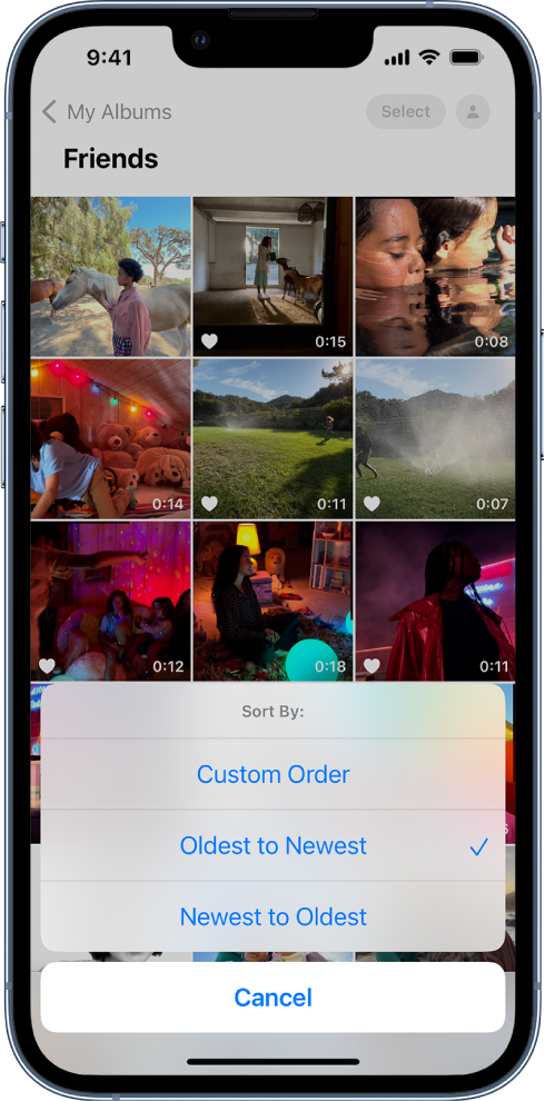 A photo album is open and the screen is filled with photo thumbnails in a grid. The Sort By options are shown at the bottom half of the screen with the following options: Custom Order, Oldest to Newest, Newest to Oldest, and Cancel. Oldest to Newest is selected.