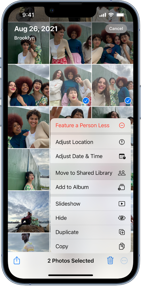 A grid of photo thumbnails fills the screen. Two of the thumbnails are selected and the More menu is open at the bottom of the screen. The Move to Shared Library option in the menu is selected.