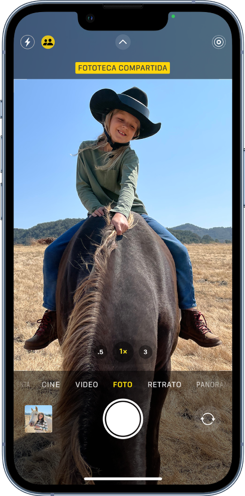 La pantalla de Cámara está abierta y un sujeto rellena el cuadro. En la parte superior de la pantalla de Cámara está el botón Fototeca compartida activado.