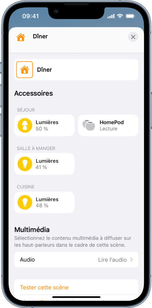 L’écran de modification d’une scène dans l’app Maison. Le nom de la scène est affiché en haut de l’écran. En dessous se trouvent trois pièces et les accessoires qui ont été ajoutés à chaque pièce dans le cadre de la scène. Près du bas de l’écran figure une section « Contenu multimédia », qui indique qu’un HomePod dans le séjour a été configuré pour lire un contenu audio. En bas de l’écran se trouve le bouton « Tester cette scène ».