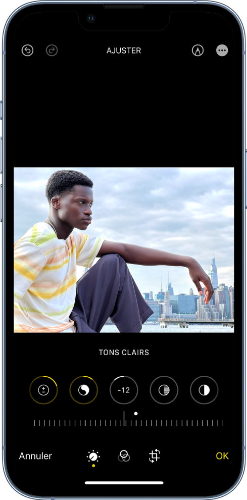 L’écran d’édition de l’app Photos. Une photo est affichée au centre de l’écran. En dessous de la photo se trouvent les boutons de modifications et la Luminosité est sélectionnée. Sous les boutons de modification, un curseur permet de régler les niveaux de luminosité. Sous ce curseur se trouvent, de gauche à droite, les boutons Annuler, Ajuster, Filtres, Recadrer et OK. Le bouton « Plus d’options » se trouve dans le coin supérieur droit.
