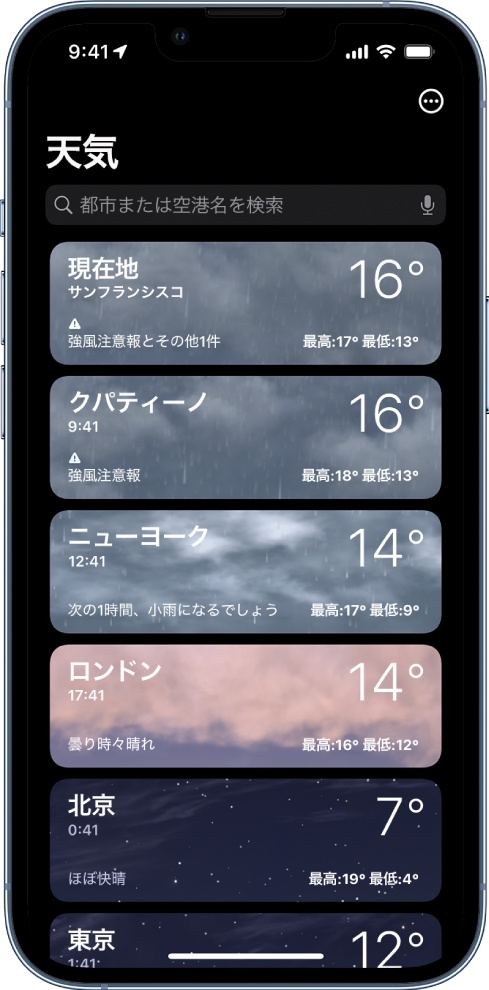都市のリスト。時刻、現在の気温、天気予報、最高/最低気温が表示されています。画面上部は検索フィールドになっていて、右上には「その他」ボタンが表示されています。