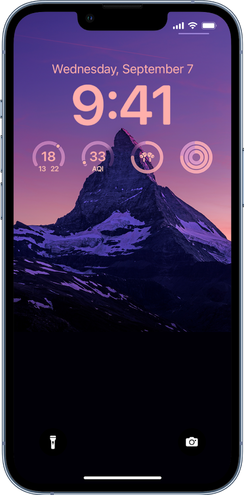 Individualizuotas „iPhone“ užrakinimo ekranas: fone yra nuotrauka, ekrano viršuje pateikiami temperatūros, oro kokybės indekso, „AirPods“ akumuliatoriaus lygio ir fizinės parengties žiedų valdikliai.