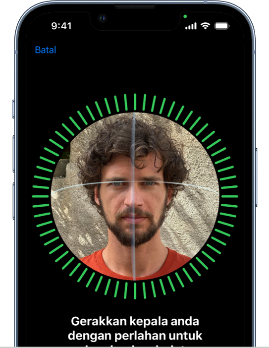 Skrin persediaan pengecaman Face ID. Muka ditunjukkan pada skrin, dikurung dalam bulatan. Teks di bawah muka mengarahkan pengguna untuk menggerakkan kepala mereka dengan perlahan untuk melengkapkan bulatan.