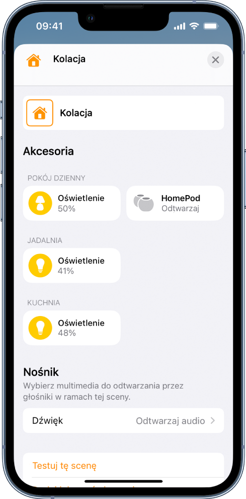 Ekran edycji sceny w aplikacji Dom. U góry ekranu widoczna jest nazwa sceny. Poniżej widoczne są trzy pokoje oraz akcesoria dodane do każdego pokoju jako część sceny. Na dole ekranu widoczna jest sekcja Multimedia, w której znajduje się HomePod umieszczony w salonie, skonfigurowany do odtwarzania audio. Na dole ekranu znajduje się przycisk Testuj tę scenę.