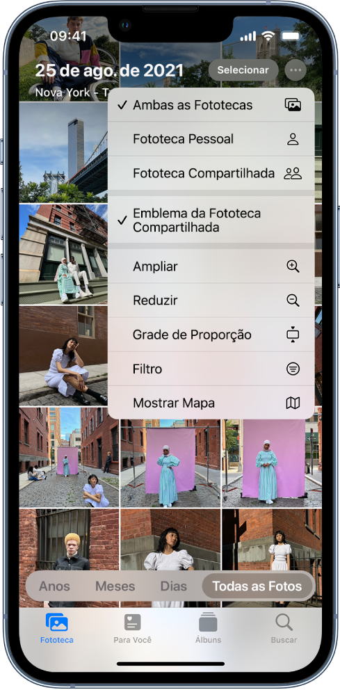 O app Fotos mostrando uma fototeca no app Fotos. O botão Mais na parte superior da tela está selecionado, mostrando as opções “Ambas as Fototecas” e “Emblema da Fototeca Compartilhada” selecionadas.