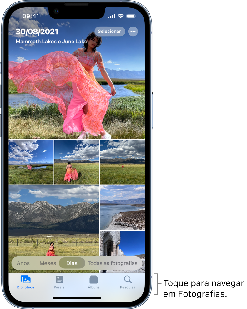 A fototeca apresentada na vista Dias. Uma seleção de miniaturas preenche o ecrã. No canto superior esquerdo do ecrã encontram‑se a data e o local onde as fotografias foram tiradas. No canto superior direito encontram‑se os botões Selecionar e “Mais opções” para partilhar fotografias e ver detalhes. Por baixo das miniaturas há opções para ver a fototeca por Anos, Meses, Dias e “Todas as fotografias”. Na parte inferior, da esquerda para a direita, estão os botões Biblioteca, Para si, Álbuns e Pesquisa.