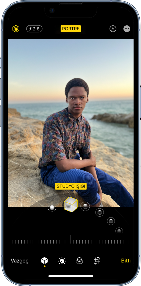 Portre modu fotoğrafının Düzenle ekranı. Ekranın sol üstünde Işık Yoğunluğu düğmesi ve Derinlik Ayarı düğmesi bulunuyor. Ekranın üst ortasında Portre düğmesi açık ve sağ üstte İşaretle düğmesi var. Ekranın ortasında fotoğraf var ve fotoğrafın altında Portre Işığı efektini seçmek için bir sürgü bulunuyor. Onun altında değeri ayarlamak için bir sürgü var. Ekranın altında soldan sağa doğru Vazgeç, Portre, Ayarla, Filtreler, Kırp ve Bitti düğmeleri bulunuyor.