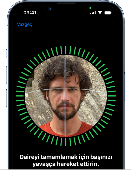 Face ID tanıma ayarlama ekranı. Ekranda, daire içine alınmış bir yüz gösteriliyor. Yüzün alt tarafında, kullanıcıya daireyi tamamlamak için kafasını yavaşça hareket ettirmesini söyleyen bir metin var.