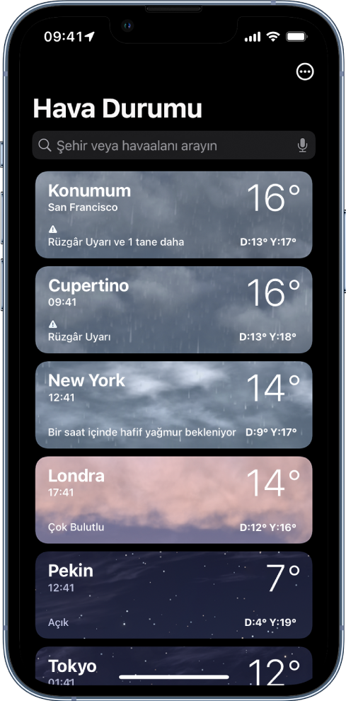Saati, o anki sıcaklığı, hava tahminini ve yüksek ve düşük sıcaklıkları gösteren şehir listesi. Ekranın en üstünde arama alanı, sağ üst köşede ise Daha Fazla düğmesi bulunuyor.