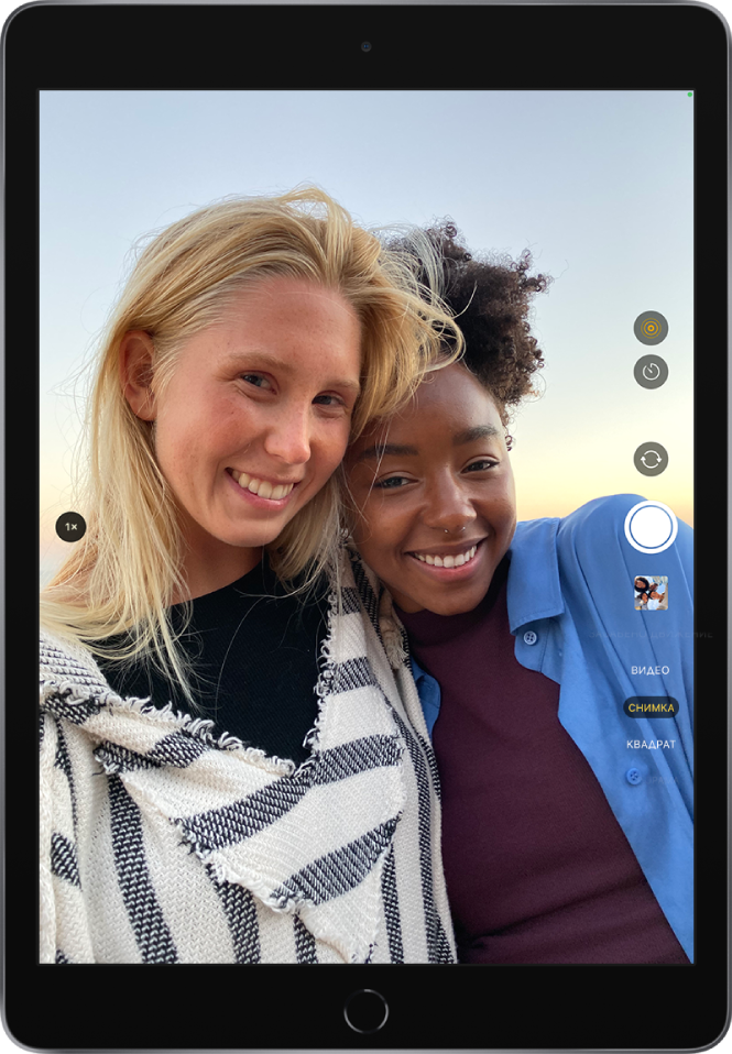 Изображение на екрана на Камера заснето на iPad Pro. Бутонът за снимане е вдясно, заедно с бутоните за превключване между камерите и бутоните за избор на фото режим.