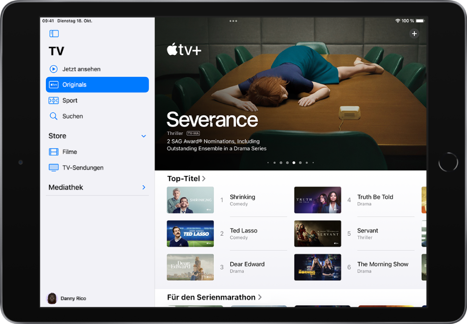 Der Apple TV+-Bildschirm mit einem empfohlenen Apple Original in der Mitte über der Reihe „Angesagt“. Auf der linken Seite sind Tabs „Jetzt ansehen“, „Originals“, „Sportarten“ und „Suchen“ von oben nach unten angeordnet.