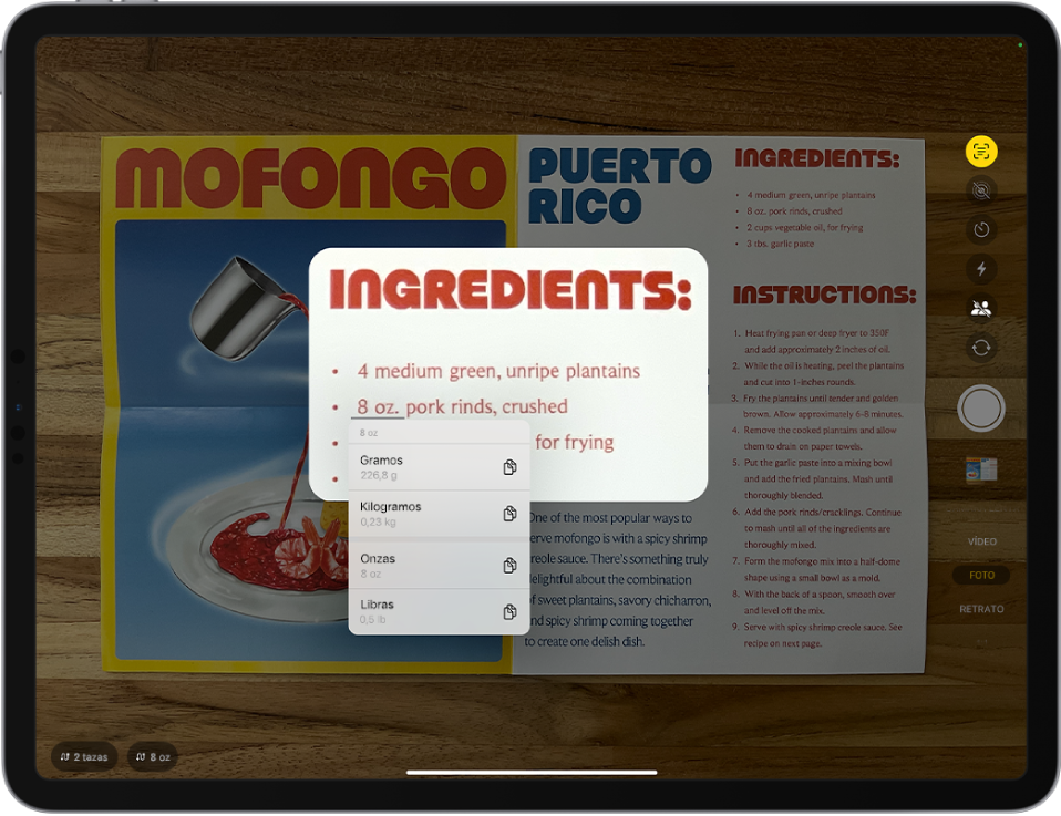 Pantalla de la app Cámara con una receta en el recuadro de la cámara. El texto del menú está seleccionado , y el texto subrayado muestra las opciones de conversión para 8 onzas. En la parte inferior de la pantalla están los botones de acciones rápidas para convertir 2 tazas y 8 onzas.