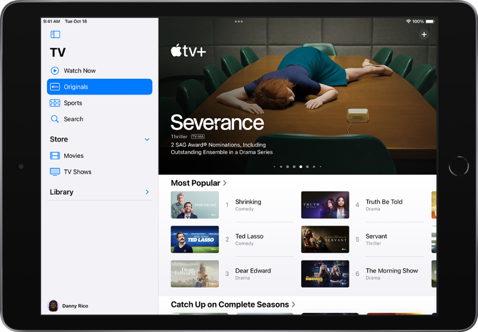 „Apple TV+“ ekranas, centre rodomas atrinktas „Apple Original“ turinys (virš eilutės „Most Popular“). Kairėje iš viršaus į apačią yra kortelės „Watch Now“, „Originals“, „Sports“ ir „Search“.