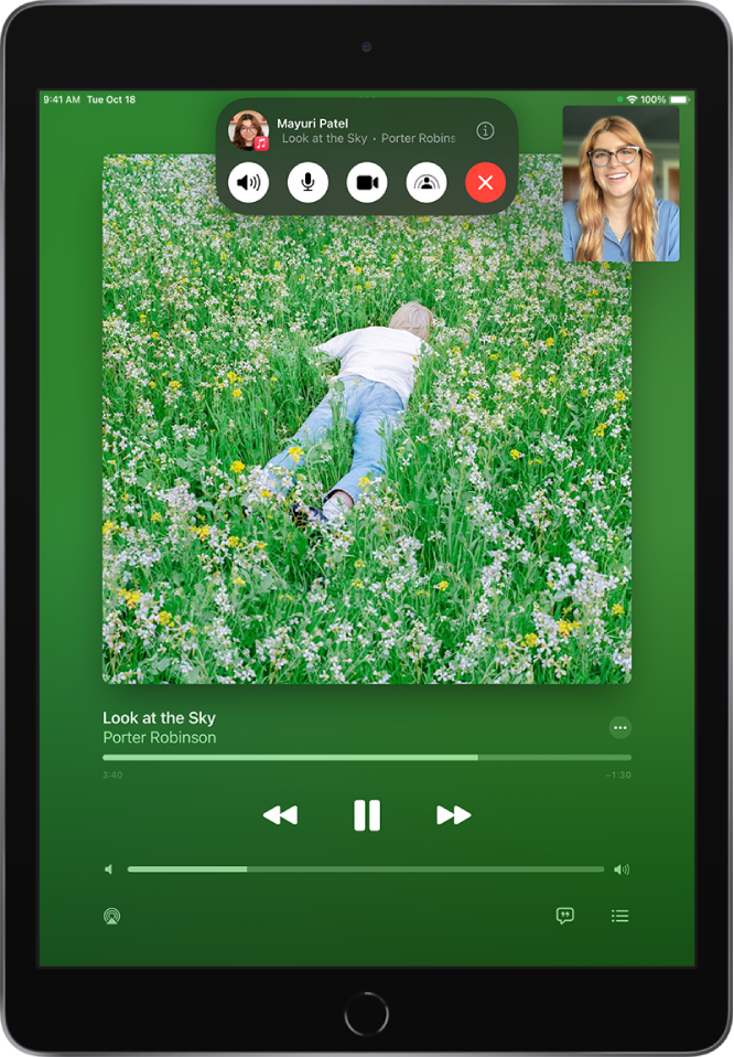 „FaceTime“ skambutis, kuriame rodomas bendrinamas garso turinys iš „Apple Music“. Albumo viršelis vaizduojamas ekrano viršutinėje dalyje, o pavadinimas ir garso valdikliai yra šiek tiek žemiau. Viršuje yra „FaceTime“ valdikliai, įskaitant mygtukus „Audio“, „Mic“, „Camera“, „SharePlay“ ir „End“. Valdiklių viršuje yra grupės ar asmens, su kuriuo kalbatės, „Apple ID“ ir mygtukas „Info“.