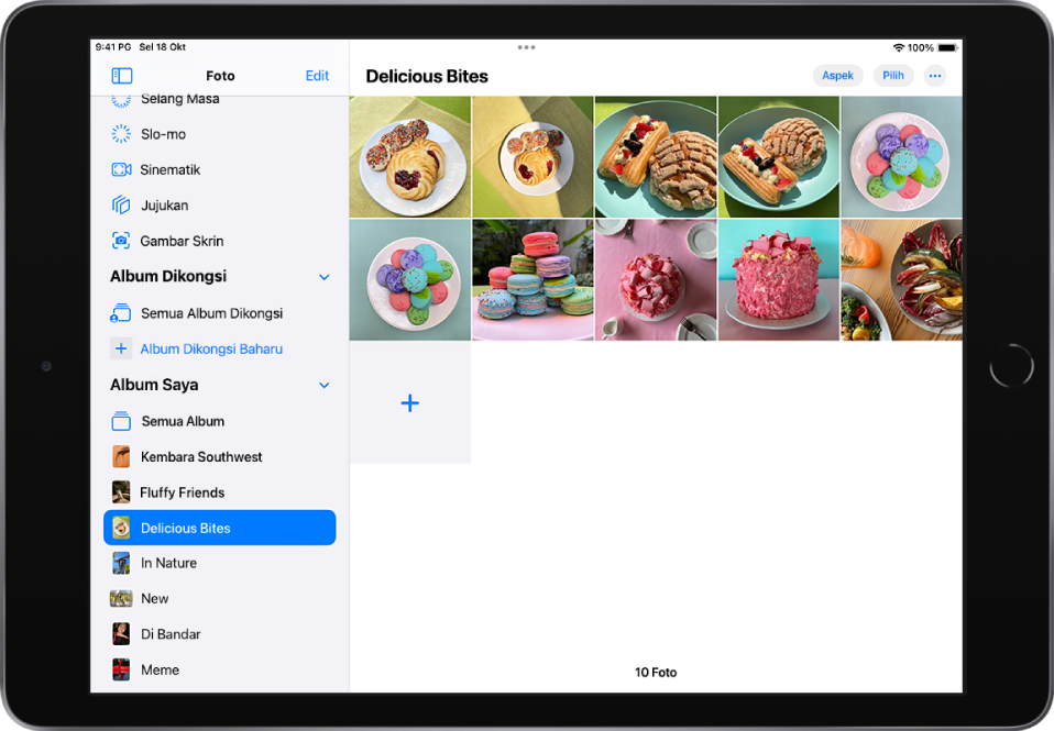 Bar sisi Foto dibuka di sebelah kiri skrin. Di bawah tajuk Album Saya, album bertajuk Makanan Lazat dipilih. Baki skrin iPad dipenuhi dengan foto dan video daripada album Makanan Lazat yang dipaparkan dalam grid.