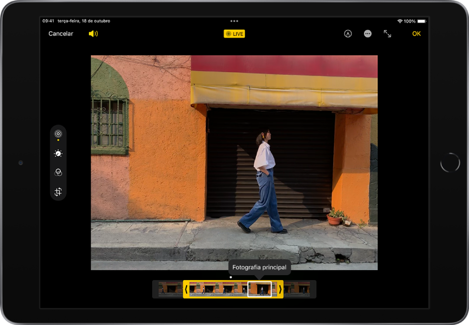 Uma Live Photo encontra‑se ao centro do ecrã de edição. O visualizador de fotogramas de Live Photos encontra-se na parte inferior do ecrã. No canto superior esquerdo estão os botões Cancelar e Volume; o botão Live Photo está em cima, ao centro; os botões Marcação, Ecrã completo e OK encontram-se no canto superior direito. As ferramentas de edição encontram-se no lado esquerdo do ecrã; de cima para baixo: Live Photo, Ajustar, Filtros e Recortar. Live Photo está selecionado.