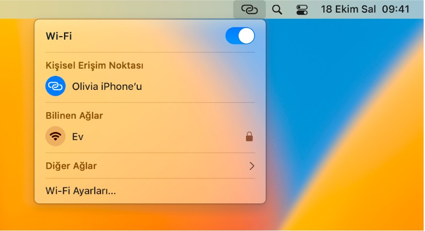 Bir iPhone’a bağlı Kişisel Erişim Noktası’nı gösteren Wi-Fi menüsünün bulunduğu Mac ekranı.