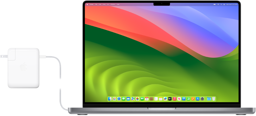 Un MacBook Pro de 16 inchi cu adaptorul de alimentare atașat.