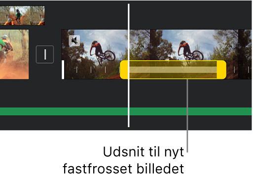 Et fastfrosset billede med gule udsnitshåndtag vist i bunden af et videoklip på tidslinjen, hvor det fastfrosne billede starter ved afspilningsmærkets placering.