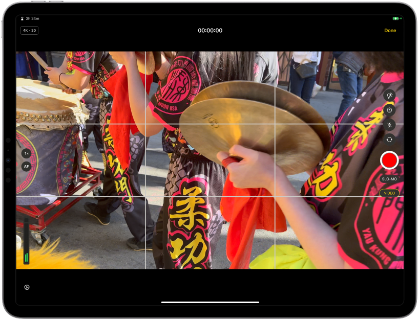 La pantalla de la cámara grabando un vídeo de un colorido desfile.