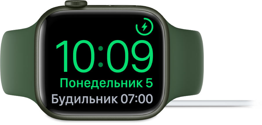Apple Watch, поставленные набок и подсоединенные к зарядному устройству. На экране отображаются значок зарядки в правом верхнем углу, текущее время под ним и время следующего будильника.