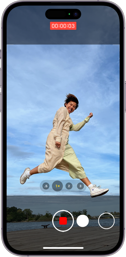 The Camera screen in Photo mode. The subject fills the center of the screen, inside the camera frame. At the bottom of the screen, the Shutter button moves to the right, demonstrating the movement of starting a QuickTake video. The video timer is at the top of the screen.