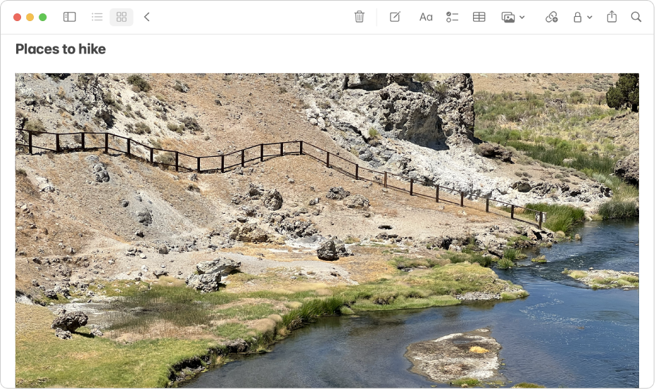 En note, der indeholder et stort foto af en bakke og en flod.