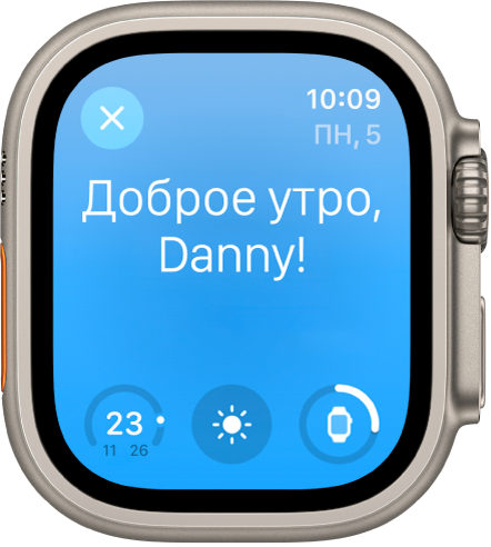 На Apple Watch показан экран пробуждения. Вверху написано: «Доброе утро!» Ниже показан уровень заряда аккумулятора.