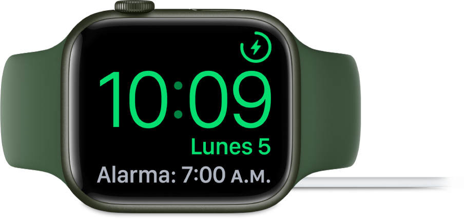 Un Apple Watch colocado de lado y conectado al cargador, con la pantalla mostrando el símbolo de carga en la esquina superior derecha, la hora actual debajo y la hora de la siguiente alarma.