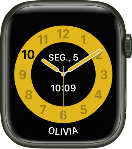 O mostrador do modo Aulas, com um relógio analógico com a data e a hora digital perto do centro. O nome da pessoa que usa o relógio encontra-se na parte inferior.