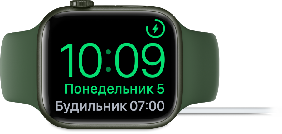 Apple Watch, поставленные набок и подсоединенные к зарядному устройству. На экране отображаются значок зарядки в правом верхнем углу, текущее время под ним и время следующего будильника.