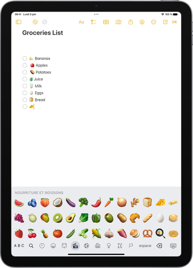 Une note est ouverte dans l’app Notes en haut de l’écran et le clavier des Emoji est ouvert en bas.