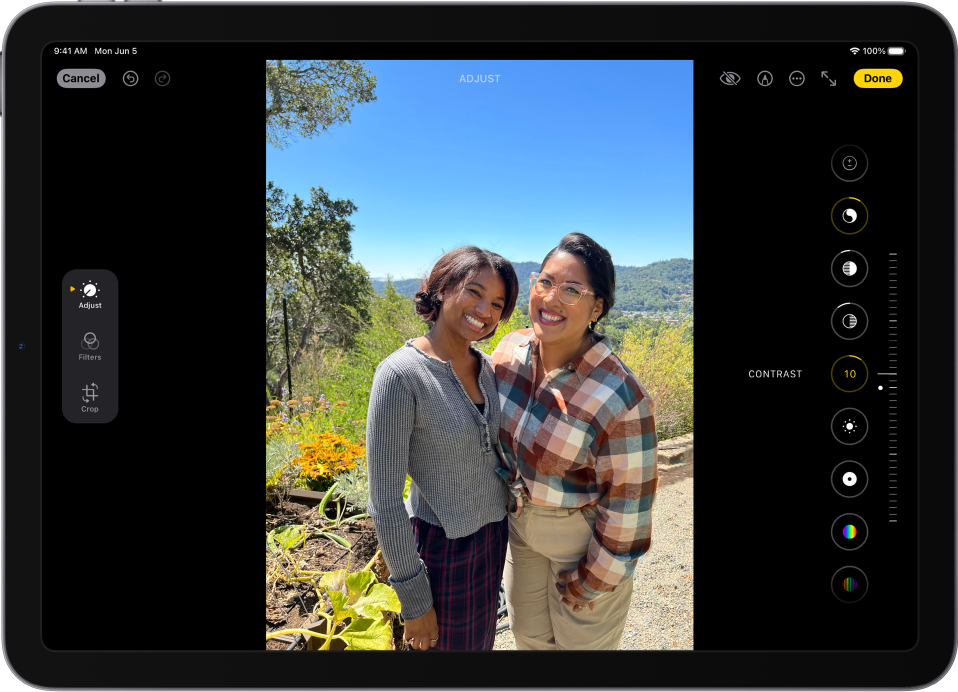 Programos „Photos“ ekrano „Edit“ centre rodoma nuotrauka. Kairėje nuotraukos pusėje yra mygtukai „Adjust“, „Filters“ ir „Crop“; pasirinktas mygtukas „Adjust“. Nuotraukos dešinėje yra efektų redagavimo mygtukai ir slankiklis, kuriuo galima koreguoti kiekvieno efekto lygį.