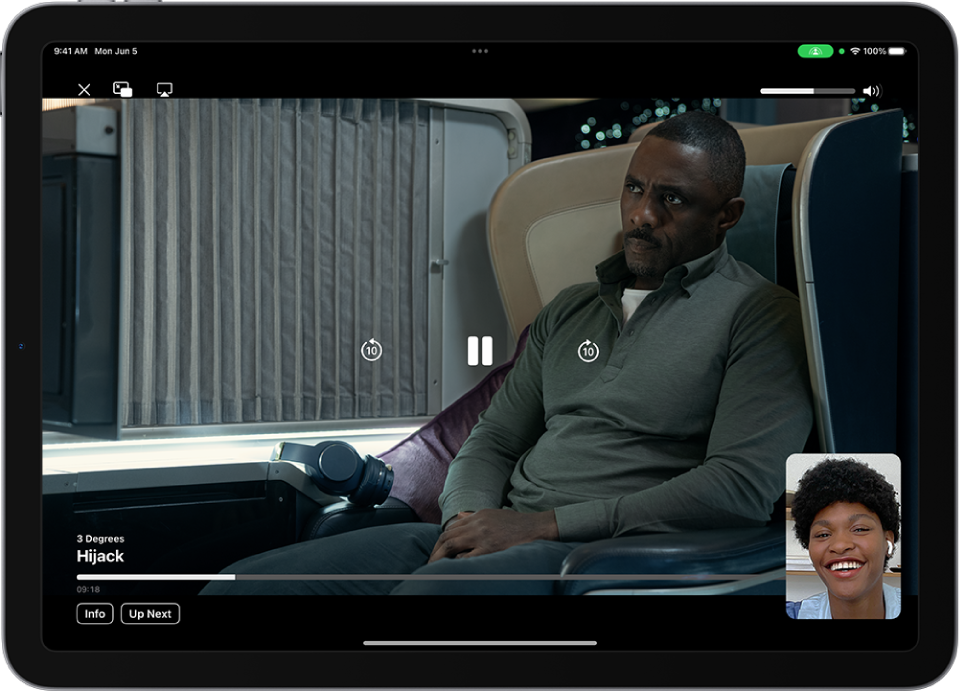 Klic FaceTime, ki prikazuje video vsebino AppleTV+, ki se deli v klicu. Oseba, ki deli vsebino, je prikazana v majhnem oknu, videoposnetek zapolni preostali del zaslona, upravljalni elementi predvajanja pa so na vrhu videoposnetka.