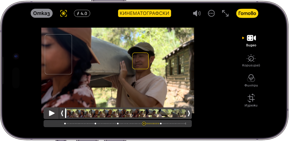 Екранът Редактирай на видео в режим Кинематографски в хоризонтална ориентация. В горната лява част на екрана са бутоните Отмени, Ръчен кинематографски и Корекция на дълбочина. Над средата на екрана е избран бутонът Кинематографски. В горната дясна част на екрана са бутоните Сила на звука, Още опции, Цял екран и Готово. Видеото е в средата на екрана и има рамка около обекта на фокус. Под видеото е визьорът за кадър, който показва точката във видеото, където обектът на фокус се променя. Бутоните за редактиране са в дясната част на екрана, от горе надолу: Видео, Корекция на цвета, Филтри и Изрязване.