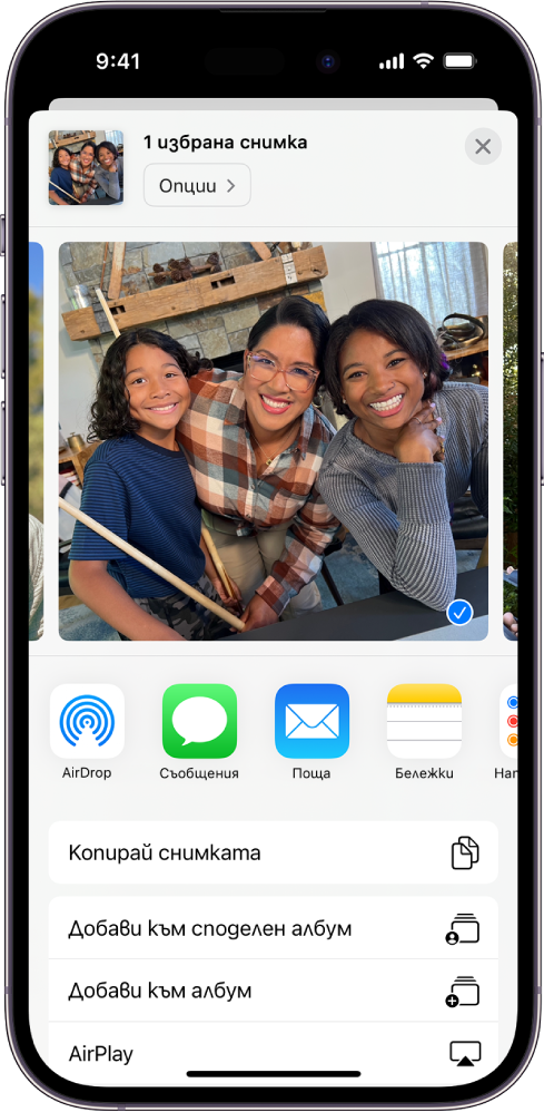 Показана е избрана снимка в горната половина на екрана на iPhone, а под нея са опциите за споделяне: AirDrop, Съобщения, Поща и Бележки. Под тези опции за споделяне са другите действия, които могат да бъдат извършени за снимката, включително Копирай снимка, Добави към Споделен албум, Добави към албум и AirPlay.
