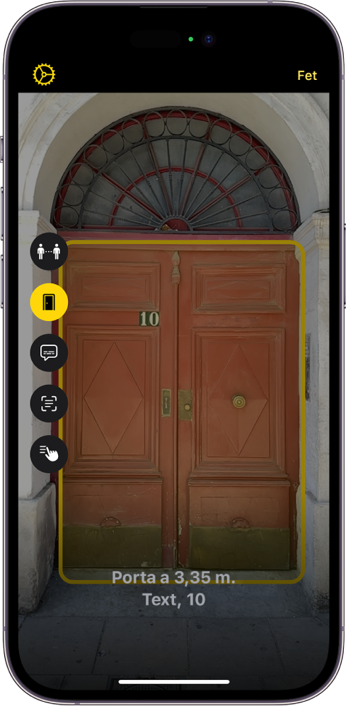Pantalla de l’app Lupa en mode de detecció que mostra una porta. A la part inferior, hi ha una descripció de la distància en què es troba i el número que té.