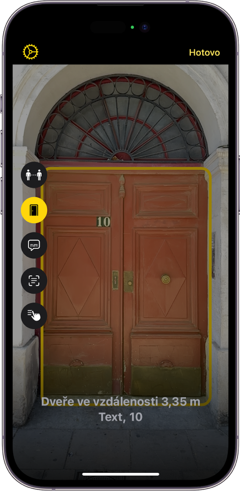 Obrazovka Lupa v režimu detekce se zobrazenými dveřmi. V dolní části se zobrazuje vzdálenost od dveří a číslo, které je na nich uvedené.