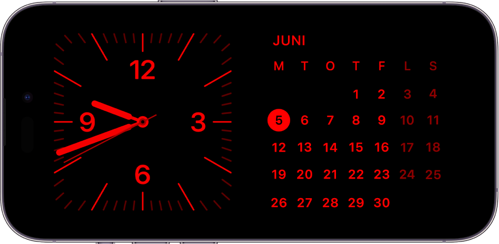 iPhone i Standby i svagt omgivende lys, hvor Ur- og Kalender-widgets vises med en rød nuance.