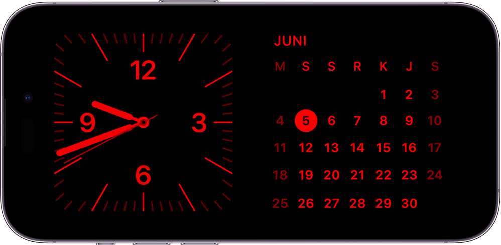 iPhone dalam mode Siaga dalam cahaya ambien rendah, menampilkan widget Jam dan Kalender dengan warna merah.