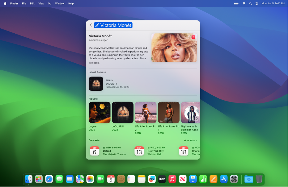 Le bureau d’un Mac avec une fenêtre Spotlight ouverte. Les résultats de la recherche montrent des détails sur un musicien et plusieurs de ses albums.