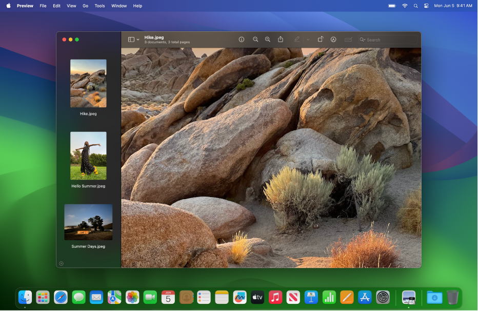 Desktop Mac diatur ke tampilan gelap, menampilkan jendela app, Dock, dan bar menu yang berwarna gelap.